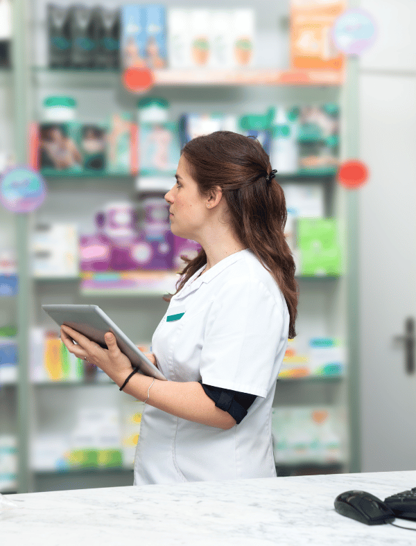 Pharmacy employee using pharmacy software to manage inventory 