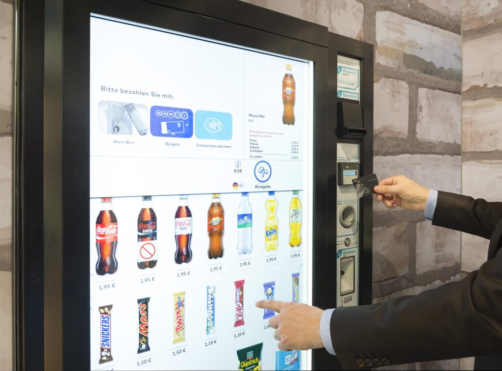 a person using a machine to pay for a drink 