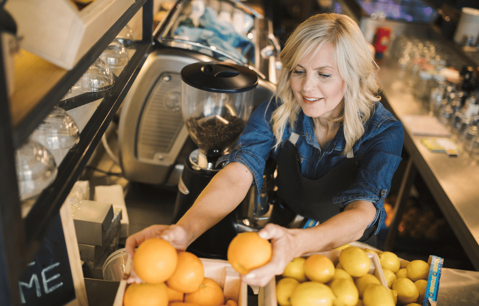 a woman working in a juice bar sorting out fruit inventory