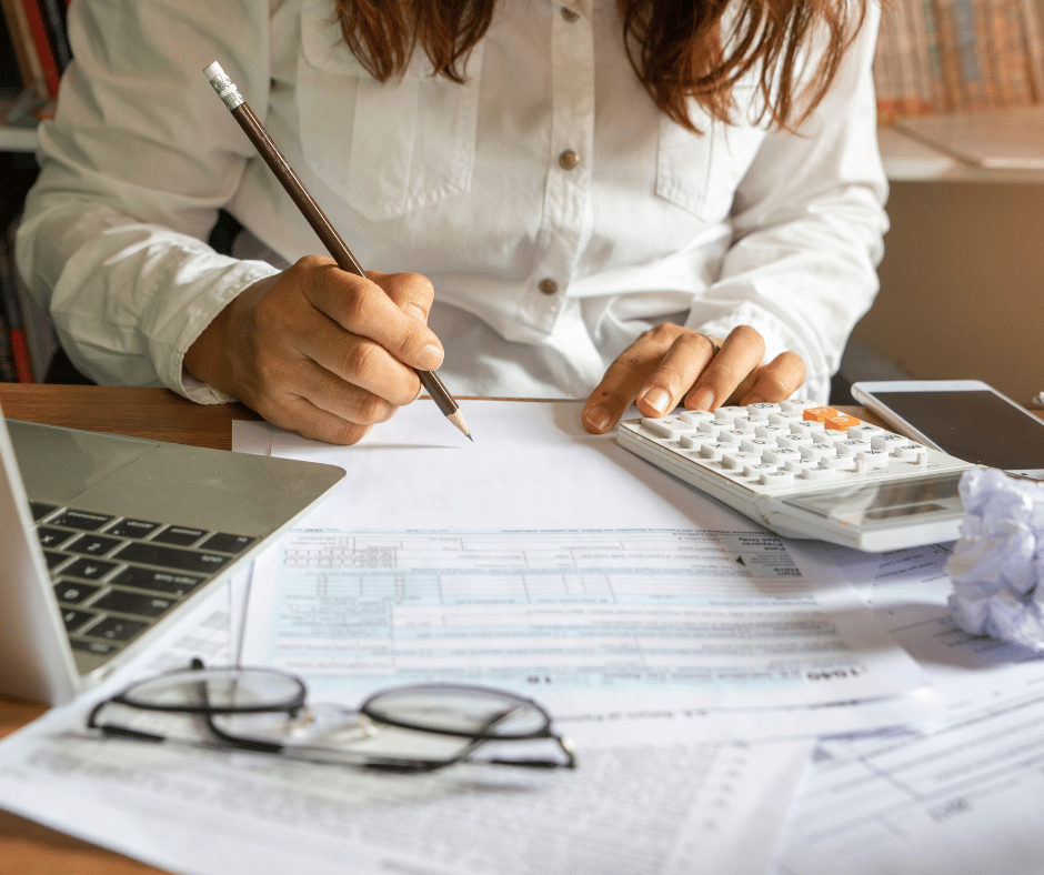 a woman working at a desk on business costs and expenses