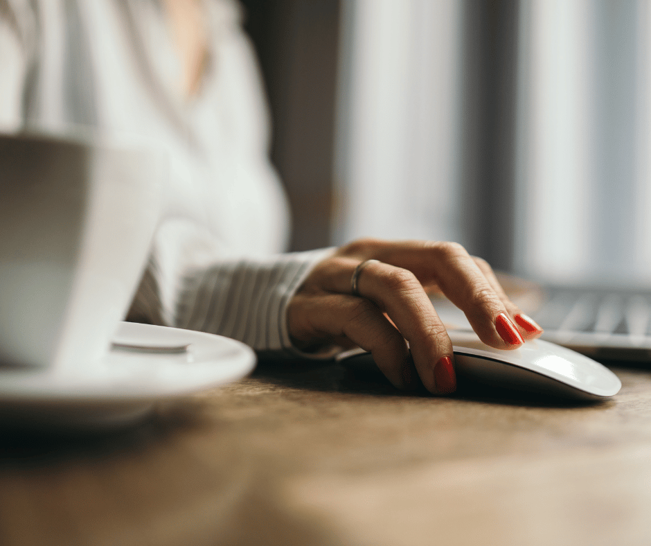 a photo of a woman working online on a computer using her mouse