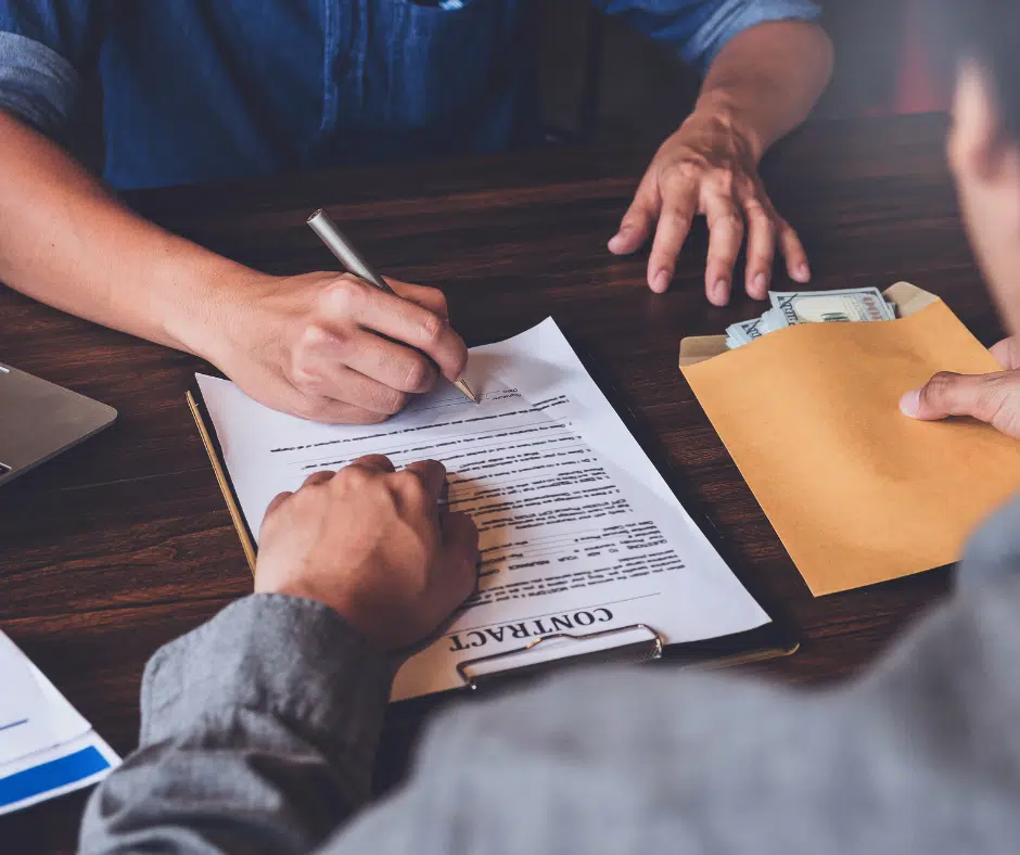 A person signing a contract to receive a small business loan.