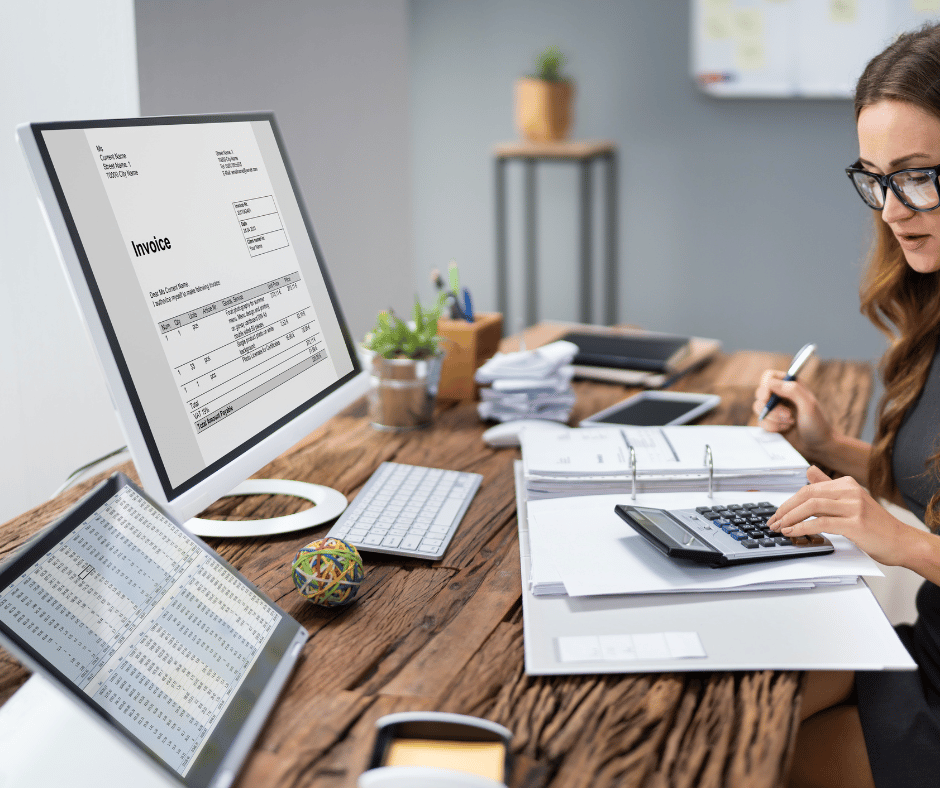 A woman working on her business accounting at her computer desk. 