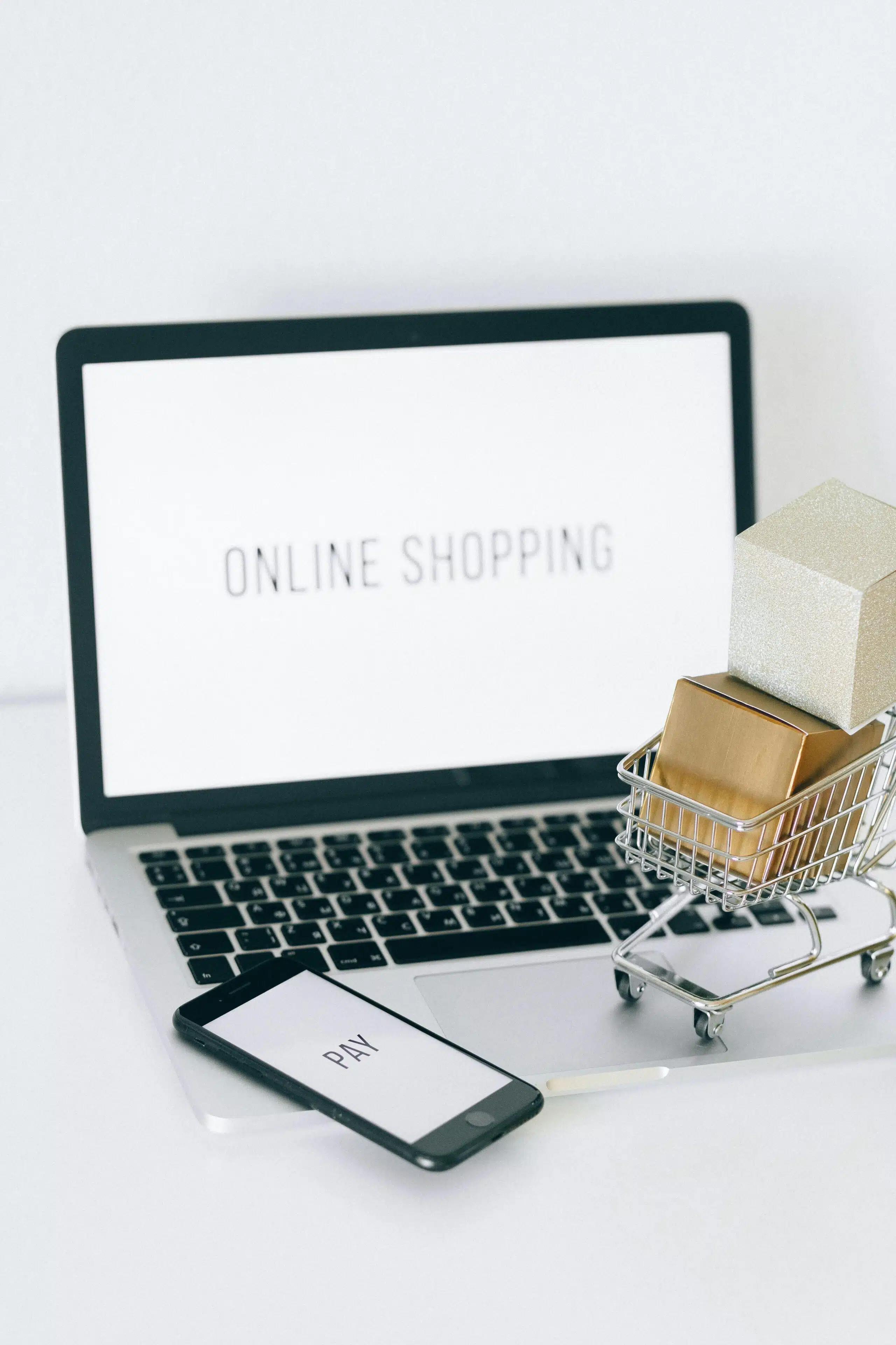 An image featuring a laptop, mobile phone, and a small shopping cart representing online retail. 