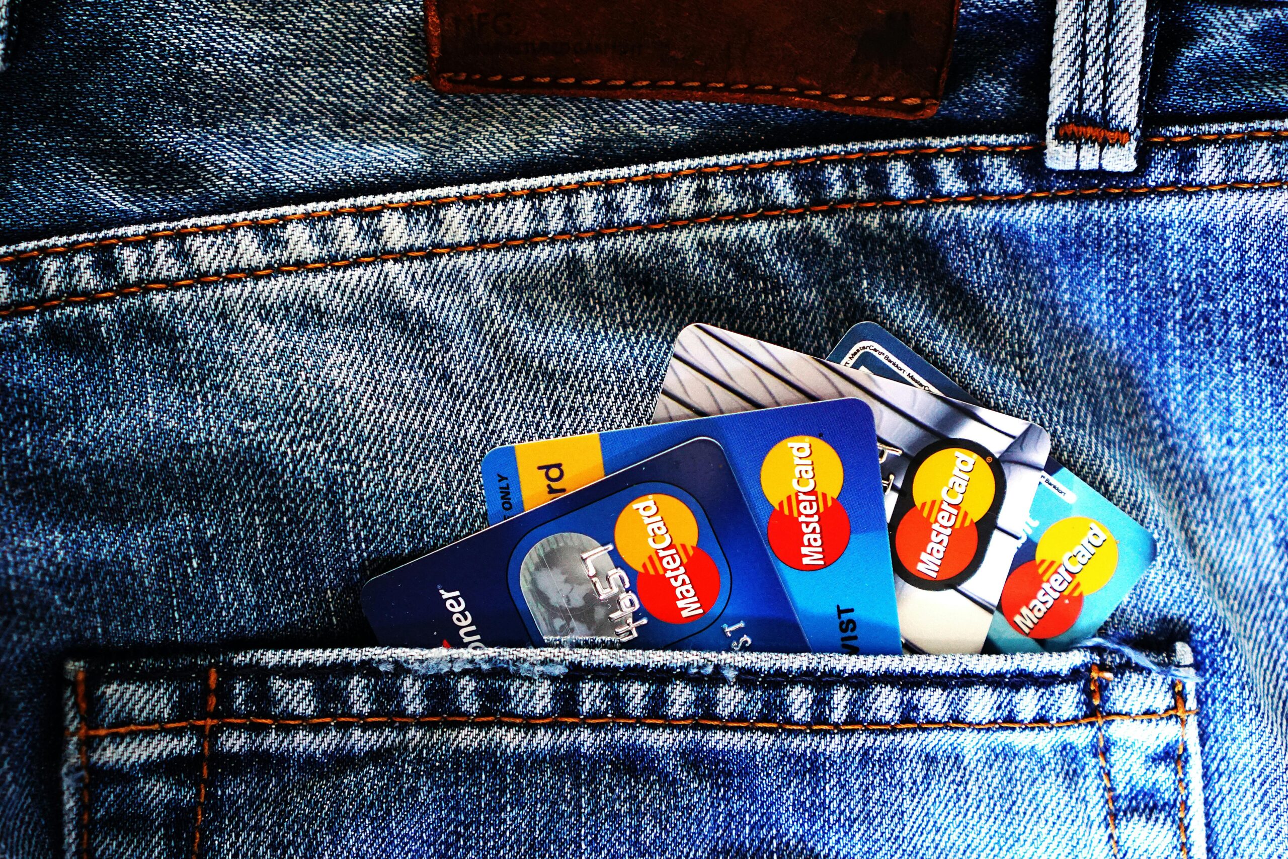 An image of a jean pants pocket showing an array of credit carts. 